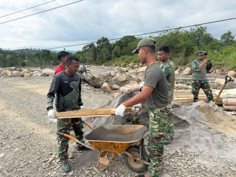 Personel Kodam Iskandar Muda bersama warga melakukan pemasangan jembatan Armco di salah satu titik strategis di wilayah Aceh Utara, Minggu (22/3/2026).