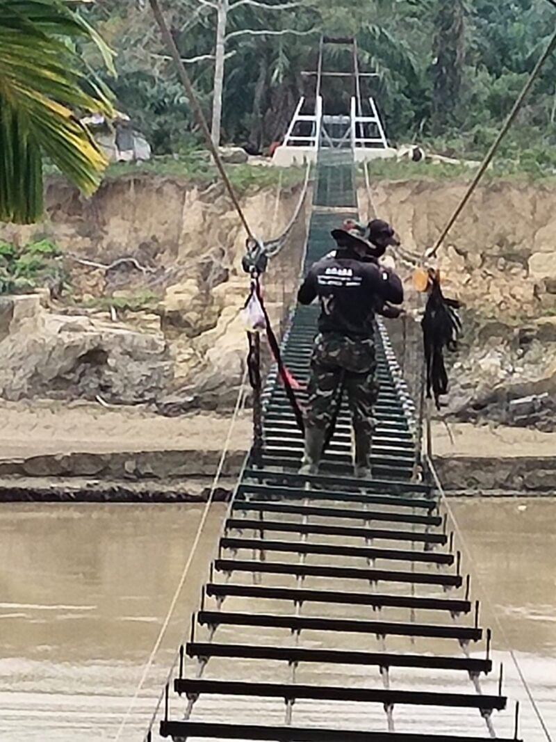 Personel Kodam Iskandar Muda bersama warga bahu-membahu dalam tahap penyelesaian salah satu jembatan perintis di wilayah Aceh (23/3/2026). 