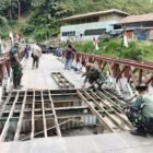 Personel Koramil 03/Timang Gajah Kodim 0119/Bener Meriah melakukan perbaikan darurat pada bagian penyangga lantai Jembatan Bailey di Desa Umah Besi, Bener Meriah, Kamis malam (26/3/2026).