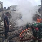 Personel TNI dari Koramil 06/Kluet Utara bersama petugas Damkar BPBD Aceh Selatan berjibaku memadamkan kobaran api yang menghanguskan 13 ruko di Desa Kota Fajar, Sabtu dini hari (28/3/2026). Tidak ada korban jiwa dalam peristiwa yang terjadi pukul 02.15 WIB tersebut.