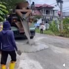 Warga Kecamatan Montasik bergotong royong menambal jalan berlubang secara swadaya menggunakan dana donasi masyarakat, Sabtu (28/2/2026). Puluhan titik jalan rusak berhasil diperbaiki demi meningkatkan keselamatan pengguna jalan.