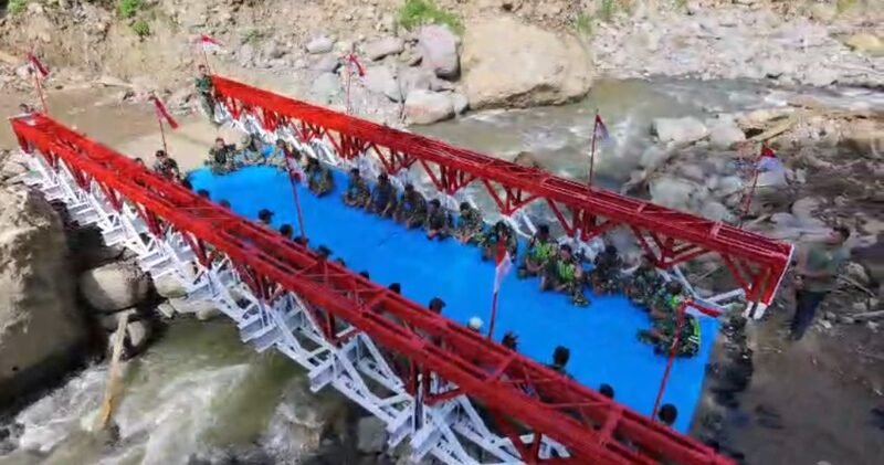 Prajurit TNI bersama masyarakat melintasi Jembatan Bailey modular yang baru selesai dibangun di Desa Meriah Jaya, Kecamatan Gajah Putih, Kabupaten Bener Meriah, Sabtu (28/2/2026), setelah sebelumnya akses utama warga terputus akibat banjir bandang dan longsor.