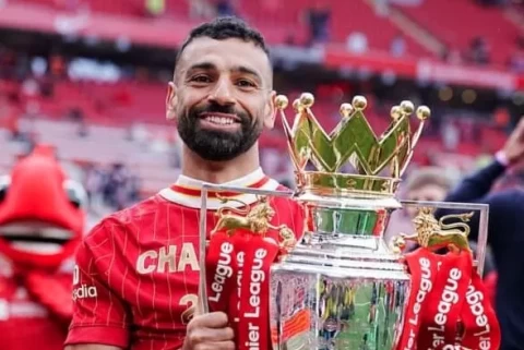 Mohamed Salah memberikan gestur hormat ke arah tribun The Kop. Setelah mendedikasikan tahun-tahun terbaiknya bagi Liverpool, 'Sang Raja Mesir' dipastikan akan menuntaskan pengabdiannya di Merseyside pada akhir musim 2025/2026 dengan segudang rekor dan trofi.