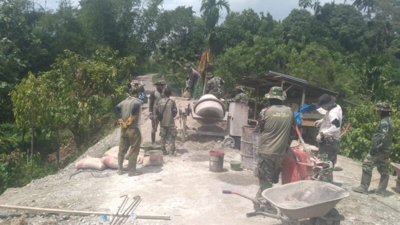 Personel Koramil 0108-03/Badar bersama warga Desa Kumbang Jaya bahu-membahu mengerjakan pengecoran pondasi Jembatan Gantung Garuda di Kecamatan Badar, Aceh Tenggara, Rabu (22/04/2026).