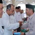 Wakil Bupati Aceh Besar Drs Syukri A Jalil menyalami JCH Lingkup Disdikbud Aceh Besar di Mesjid Baitul Makmur, Sibreh, Kecamatan Sukamakmur, Kamis (23/4/2026). FOTO/MC ACEH BESAR