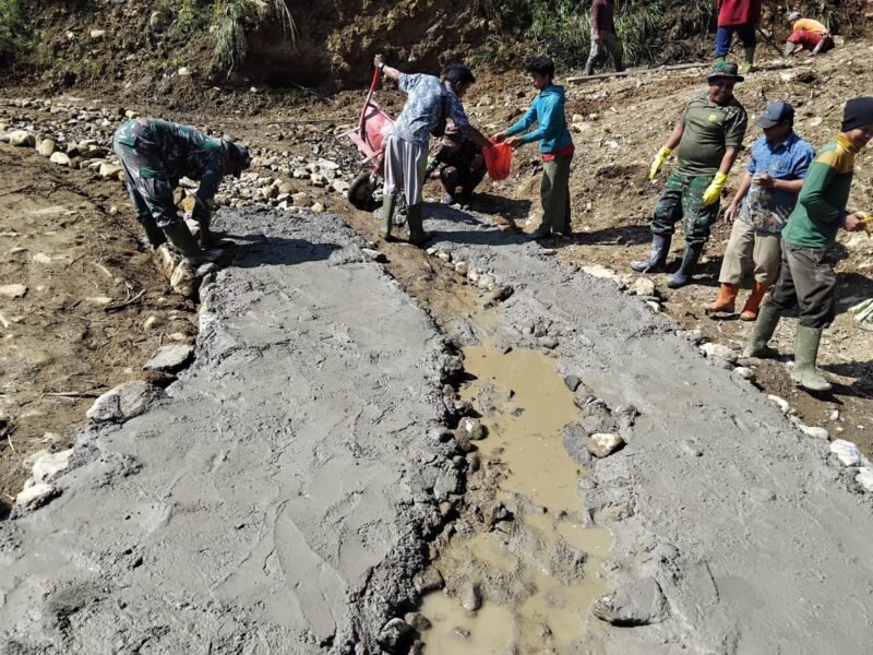 Personel TNI dari Kodim 0119/Bener Meriah bersama warga Desa Uning Mas bahu-membahu mempercepat pembangunan Jembatan Aramco di Kecamatan Permata, Bener Meriah, Jumat (24/4/2026).