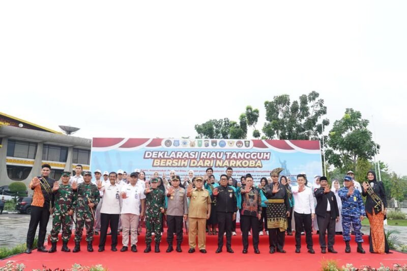 Plt Gubernur Riau SF. Hariyanto didampingi Kapolda Riau Irjen Pol Herry Heryawan memasangkan rompi kepada perwakilan personel saat Apel Kesiapan Satgas Anti Narkoba di Lapangan Apel Gubernur Riau, Sabtu (25/4/2026). 