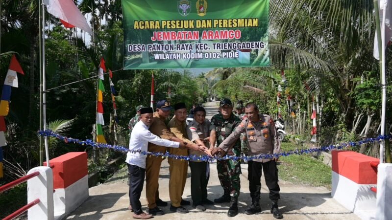 Prosesi peusijuek (tepung tawar) dan pemotongan pita oleh unsur Muspika Kecamatan Trenggadeng menandai peresmian Jembatan Aramco yang menghubungkan Desa Panton Raya dan Desa Tampui, Pidie Jaya, Senin (27/04/2026). 