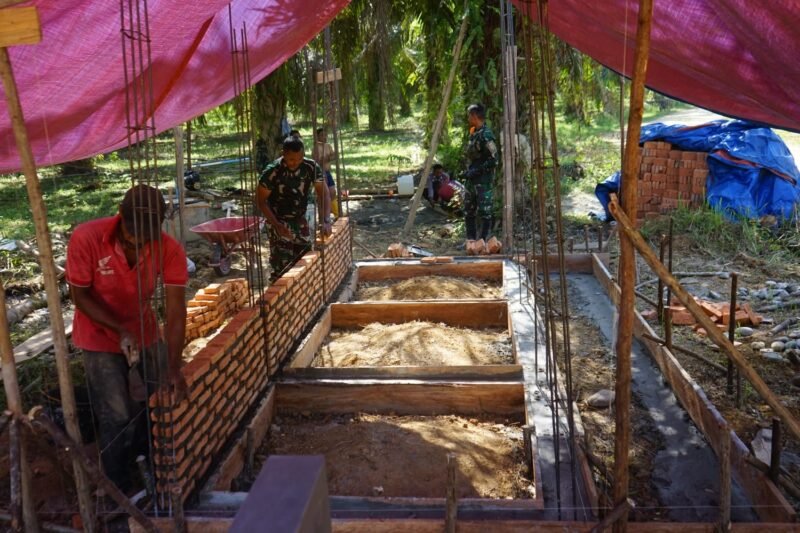 Personel Satgas TMMD Reguler ke-128 Kodim 0117/Aceh Tamiang bersama warga Desa Suka Makmur melakukan pemasangan batu bata untuk pembangunan fasilitas MCK, Selasa (28/04/2026).