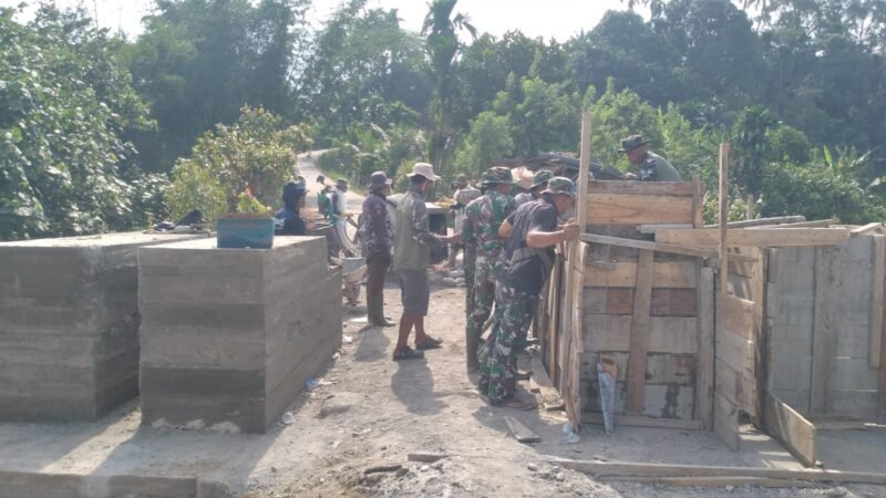 Personel Kodim 0108/Agara bersama warga Desa Kumbang Jaya bahu-membahu mengangkut material pembangunan jembatan gantung perintis, Sabtu (02/05/2026). 