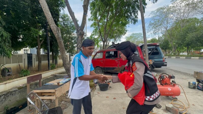 Personel Polwan Ditsamapta Polda Aceh menyerahkan paket sembako kepada salah seorang warga lansia di Banda Aceh dalam kegiatan 