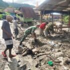 Babinsa Posramil Ketambe, Serda Jaya Aspin, bahu-membahu bersama warga Desa Jati Sara, Aceh Tenggara, membersihkan sisa material lumpur pascabanjir menggunakan peralatan seadanya, Senin (11/05/2026).