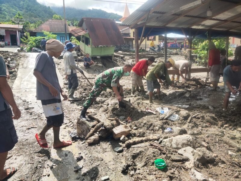 Babinsa Posramil Ketambe, Serda Jaya Aspin, bahu-membahu bersama warga Desa Jati Sara, Aceh Tenggara, membersihkan sisa material lumpur pascabanjir menggunakan peralatan seadanya, Senin (11/05/2026).