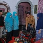 Ketua TP-PKK Aceh Besar, Hj. Rita Mayasari, melakukan foto bersama usai serahkan bantuan satu unit kursi roda dan Bantuan sosial kepada Ainal Mardhiah (74), di Gampong Lampenerut Ujong Blang, Kecamatan Darul Imarah, Aceh Besar, Selasa (12/05/2026). FOTO/MC ACEH BESAR