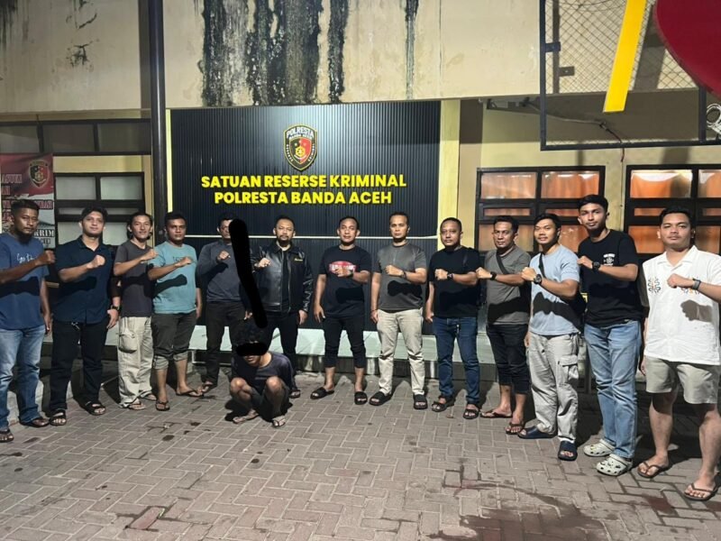 Kasat Reskrim Polresta Banda Aceh, Kompol Miftahuda Dizha Fezuono (tengah), menghadirkan tersangka IFD (24) beserta barang bukti telepon seluler milik korban dalam konferensi pers di Mapolresta Banda Aceh, Sabtu (16/5/2026). Tersangka nekat menganiaya mantan rekan kerjanya dengan balok kayu demi merampas ponsel untuk modal bermain judi online.