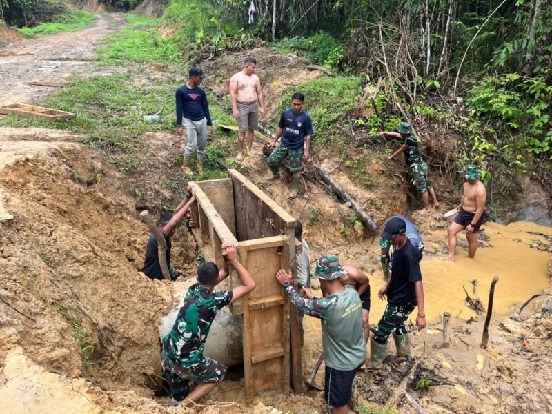 Personel Satgas TMMD Reguler ke-128 Kodim 0117/Aceh Tamiang bersama warga Desa Suka Makmur bergotong royong membangun kupingan gorong-gorong untuk memperkuat ketahanan infrastruktur jalan desa, Minggu (17/5/2026).
