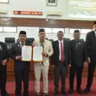 Wakil Bupati Aceh Besar Drs H Syukri didampingi Sekdakab Aceh Besar Bahrul Jamil SSos MSi foto bersama Ketua DPRK Abdul Muchti dan para Wakil Ketua DPRK Aceh Besar serta Sekretaris DPRK Aceh Besar seusai menyampaikan jawaban atas pemandangan umum Fraksi-fraksi DPRK Aceh Besar tentang Rancangan Qanun Penyertaan Modal Daerah Kabupaten Aceh Besar pada Perusahaan Umum Daerah Air Minum Tirta Mountala Kabupaten Aceh Besar di Gedung DPRK Aceh Besar, Selasa (19/5/2026). FOTO/ MC ACEH BESAR