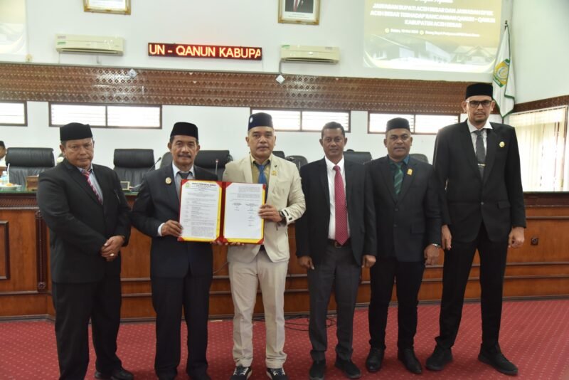 Wakil Bupati Aceh Besar Drs H Syukri didampingi Sekdakab Aceh Besar Bahrul Jamil SSos MSi foto bersama Ketua DPRK Abdul Muchti dan para Wakil Ketua DPRK Aceh Besar serta Sekretaris DPRK Aceh Besar seusai menyampaikan jawaban atas pemandangan umum Fraksi-fraksi DPRK Aceh Besar tentang Rancangan Qanun Penyertaan Modal Daerah Kabupaten Aceh Besar pada Perusahaan Umum Daerah Air Minum Tirta Mountala Kabupaten Aceh Besar di Gedung DPRK Aceh Besar, Selasa (19/5/2026). FOTO/ MC ACEH BESAR