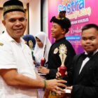 Kepala Dinas Pendidikan Aceh, Murthalamuddin, menyerahkan piala juara umum Festival Lomba Seni dan Sastra Siswa Nasional (FLS3N) Jenjang Pendidikan Khusus Tahun 2026 kepada kontingen Kabupaten Aceh Besar di Aula Dinas Pendidikan Aceh, Rabu (20/5/2026).