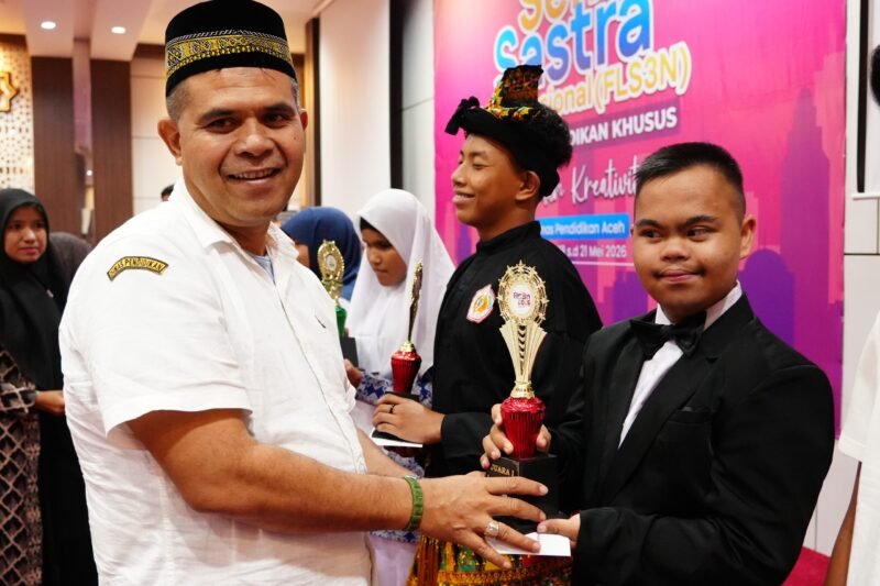 Kepala Dinas Pendidikan Aceh, Murthalamuddin, menyerahkan piala juara umum Festival Lomba Seni dan Sastra Siswa Nasional (FLS3N) Jenjang Pendidikan Khusus Tahun 2026 kepada kontingen Kabupaten Aceh Besar di Aula Dinas Pendidikan Aceh, Rabu (20/5/2026).