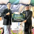 Bupati Aceh Besar, H Muharram Idris menyerahkan piala kepada juara I pawai mobil hias menyambut Tahun Baru Islam 1448 H di depan Masjid Jamik Lambaro, Kecamatan Ingin Jaya, Aceh Besar, Senin (15/06/2026) malam. FOTO/MC ACEH BESAR