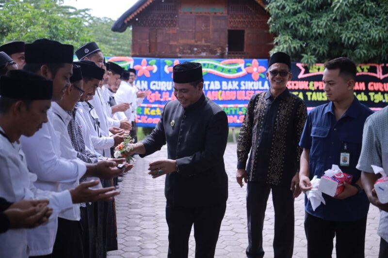 Bupati Aceh Besar H Muharram Idris bersama Ulama Karismatik Aceh Abu Athailah melakukan prosesi peusijuek kepada ratusan guru Beut Kitab bak Sikula, di halaman Gedung Dekranasda Aceh Besar, Kamis (18/6/2026). FOTO/ MC ACEH BESAR
