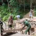 Babinsa Koramil 0108-04/Babussalam, Koptu Suharto, bersama warga Desa Lawe Sikap I bahu-membahu memasang mal cor pondasi jembatan beton di Kecamatan Babussalam, Kabupaten Aceh Tenggara, Jumat (19/06/2026).
