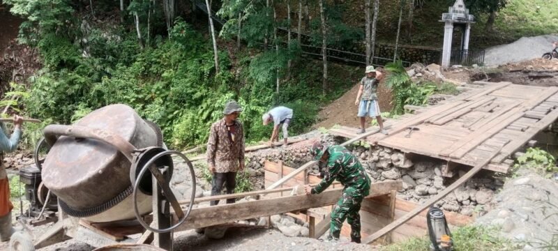 Babinsa Koramil 0108-04/Babussalam, Koptu Suharto, bersama warga Desa Lawe Sikap I bahu-membahu memasang mal cor pondasi jembatan beton di Kecamatan Babussalam, Kabupaten Aceh Tenggara, Jumat (19/06/2026).