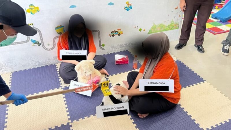 Tersangka kasus dugaan penganiayaan batita memperagakan adegan saat rekonstruksi yang digelar oleh Satreskrim Polresta Banda Aceh bersama Jaksa Penuntut Umum Kejari Banda Aceh di Baby Preneur Daycare, kawasan Lamgugob, Banda Aceh, Jumat (19/6/2026).