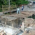 Personel Babinsa Kodim 0108/Aceh Tenggara bersama warga Desa Lawe Sikap 1, Kecamatan Babussalam, bergotong royong memasang besi penahan rangka utama jembatan beton, Sabtu (27/6/2026).