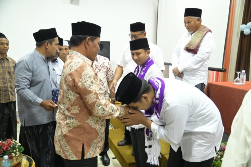 Bupati Aceh Besar, H Muharram Idris memasang sal secara simbolis kepada Jamaah Umrah para Juara MTQ dan MKQ di Gedung Dekranasda, Gampong Gani, Kecamatan Ingin Jaya, Aceh Besar, Sabtu (27/06/2026). FOTO/MC ACEH BESAR