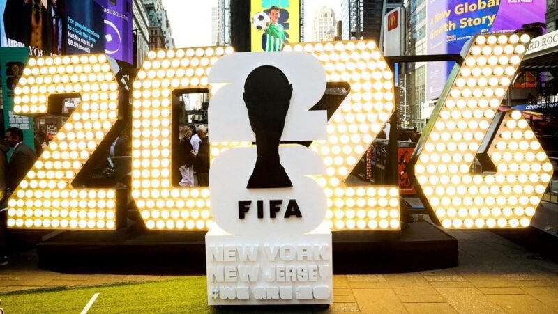 Logo Piala Dunia 2026. Amerika Serikat selaku salah satu tuan rumah menuai gelombang kecaman setelah menerapkan kebijakan visa dan perizinan masuk yang dinilai terlalu pilih-pilih bagi tim maupun suporter dari negara tertentu.