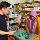 Seorang BSI Agen sedang melayani nasabah di salah satu wilayah pedesaan. Hingga Mei 2026, jaringan BSI Agen telah mencapai lebih dari 130 ribu agen di seluruh Indonesia untuk mempermudah akses layanan perbankan syariah, mulai dari transaksi harian hingga pendaftaran BPJS Ketenagakerjaan BPU.