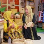Ketua Dekranasda Aceh Besar Hj Rita Mayasari, memperlihatkan salah satu produk unggulan Stand Dekranasda Aceh Besar pada ajang Pameran Kriya dan Wastra Dekranasda se-Indonesia yang digelar dalam rangka HUT Dekranas ke-46 Tahun 2026 di Trans Studio Mall Makassar, Sulawesi Selatan, Kamis (9/7/2026). FOTO/ PROKOPIM PEMKAB ACEH BESAR