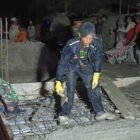 Babinsa Desa Lawe Sikap I Koptu Suharto bersama warga bahu-membahu melakukan pengecoran lantai jembatan beton hingga malam hari di Desa Lawe Sikap I, Kecamatan Babussalam, Aceh Tenggara, Kamis (9/7/2026).