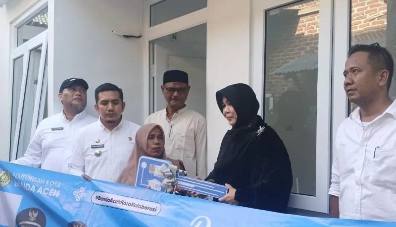 Wali Kota Banda Aceh, Illiza Sa'aduddin Djamal, menyerahkan kunci secara simbolis kepada salah satu warga penerima manfaat program rumah layak huni di Banda Aceh, Rabu (15/7/2026).