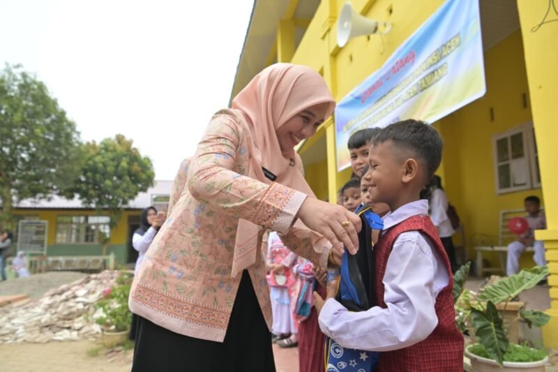 Ketua Dharma Wanita Persatuan (DWP) Aceh, Malahayati M. Nasir, menyerahkan paket bantuan perlengkapan sekolah berupa tas dan buku kepada seorang siswa sekolah dasar di Kabupaten Aceh Tamiang, Selasa (14/7/2026). (Foto: Dok. Humas Aceh)