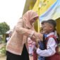 Ketua Dharma Wanita Persatuan (DWP) Aceh, Malahayati M. Nasir, menyerahkan paket bantuan perlengkapan sekolah berupa tas dan buku kepada seorang siswa sekolah dasar di Kabupaten Aceh Tamiang, Selasa (14/7/2026). (Foto: Dok. Humas Aceh)