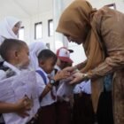 Ketua TP PKK Aceh, Marlina Muzakir (Kak Na), secara simbolis menyerahkan bantuan seragam sekolah kepada salah seorang siswa korban banjir bandang di Masjid Baitul Hamdi, Desa Pantan Nangka, Kecamatan Linge, Aceh Tengah, Rabu (22/7/2026).