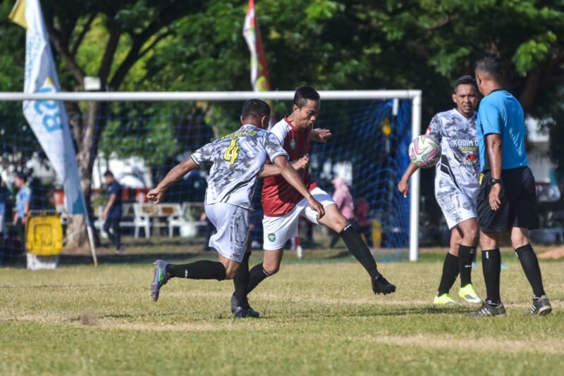 Aksi saling berebut bola antara pemain tim Kodim Aceh Jaya dan Kodim Nagan Raya dalam laga Piala Pangdam IM Cup 2026 di Lapangan Blang Padang, Banda Aceh, Minggu (26/7/2026). Kodim Aceh Jaya berhasil menang dengan skor tipis 1-0.
