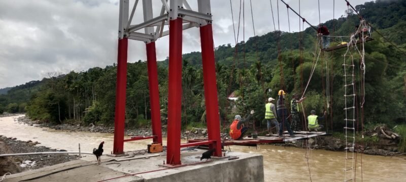 Personel TNI Kodim 0116/Nagan Raya bersama warga bergotong royong memasang lantai dan menyelaraskan sling Jembatan Gantung Perintis Garuda di atas aliran sungai Beutong Ateuh Banggalang, Nagan Raya, Aceh, Senin (27/7/2026). 