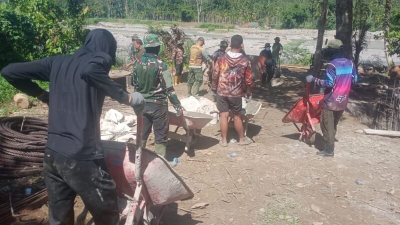 Personel TNI dari Satgas Kodim 0108/Aceh Tenggara dan Yon TP 855/RD bersama masyarakat bergotong royong memasang rangka besi tulangan pondasi Jembatan Gantung Perintis di Desa Lawe Ger-Ger, Kecamatan Ketambe, Aceh Tenggara, Kamis (30/7/2026).