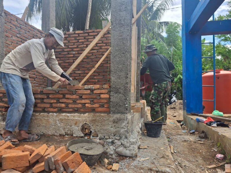 Personel Satgas TMMD Ke-129 Kodim 0102/Pidie bersama warga bergotong royong memasang batu bata untuk dinding fasilitas MCK di Meunasah Blang Cot, Kecamatan Sakti, Kabupaten Pidie, Selasa (4/8/2026). 