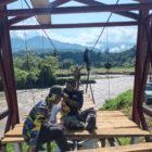 Proses pemasangan papan lantai Jembatan Gantung Perintis yang dikerjakan oleh personel Kodim 0108/Aceh Tenggara dan warga untuk memperlancar akses ke areal perkebunan di Desa Kuta Ujung, Aceh Tenggara, Senin (3/8/2026).