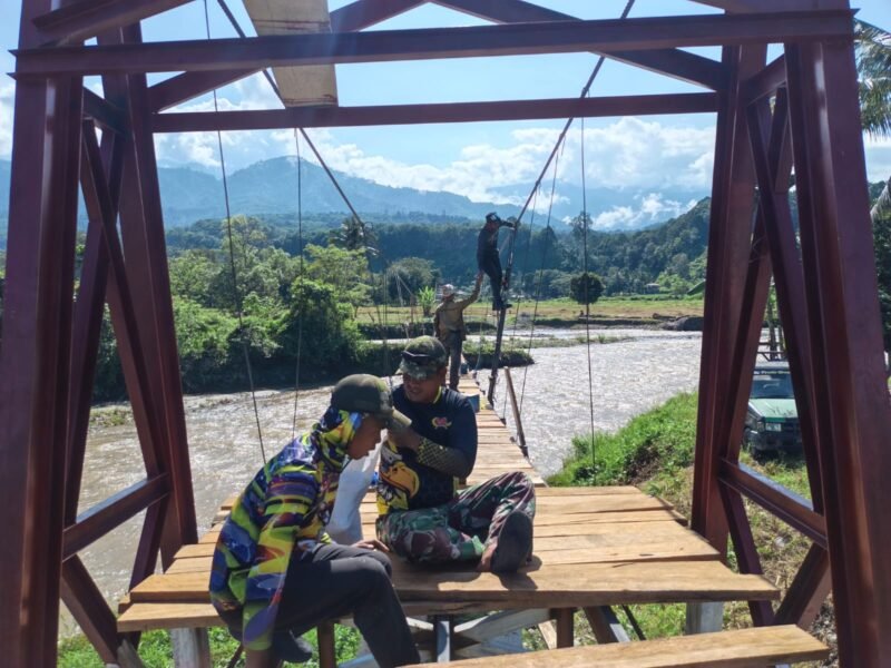 Proses pemasangan papan lantai Jembatan Gantung Perintis yang dikerjakan oleh personel Kodim 0108/Aceh Tenggara dan warga untuk memperlancar akses ke areal perkebunan di Desa Kuta Ujung, Aceh Tenggara, Senin (3/8/2026).