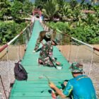 Personel Satgas Jembatan bersama warga bergotong royong melakukan pengecatan lantai Jembatan Gantung Perintis tahap finishing di Desa Kati Maju, Kecamatan Ketambe, Aceh Tenggara, Rabu (5/8/2026).