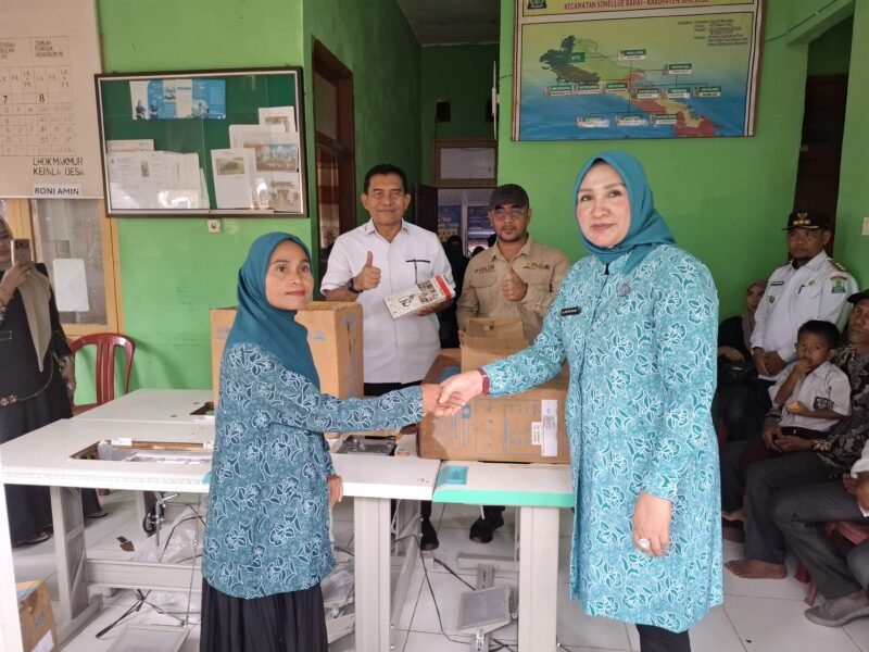Ketua TP PKK Aceh Marlina Muzakir (Kak Na) menyerahkan bantuan mesin jahit dan mesin obras kepada Ketua TP PKK Desa Lhok Makmur Ermiliana di Kantor Desa Lhok Makmur, Simeulue, Rabu (5/8/2026).