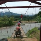 Personel Babinsa Kodim 0108/Aceh Tenggara, Yon TP 855/RD, dan warga setempat bergotong royong memasang tiang hanger pada pembangunan Jembatan Gantung Perintis di Desa Kuta Ujung, Kecamatan Darul Hasanah, Aceh Tenggara, Sabtu (8/8/2026).