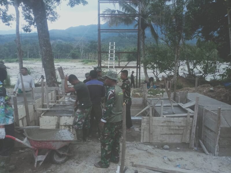 Personel TNI bersama warga bahu-membahu melakukan pengecoran lantai jembatan beton di Desa Bunga Melur, Kecamatan Deleng Pokhkisen, Kabupaten Aceh Tenggara, Jumat (7/8/2026).