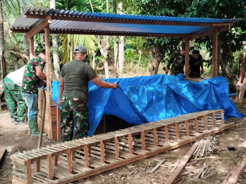 Personel Satgas TMMD ke-129 Kodim 0102/Pidie bersama warga membangun kolam budidaya ikan lele dan kandang ayam petelur di Desa Lhok Panah, Kecamatan Sakti, Kabupaten Pidie, Minggu (9/8/2026).